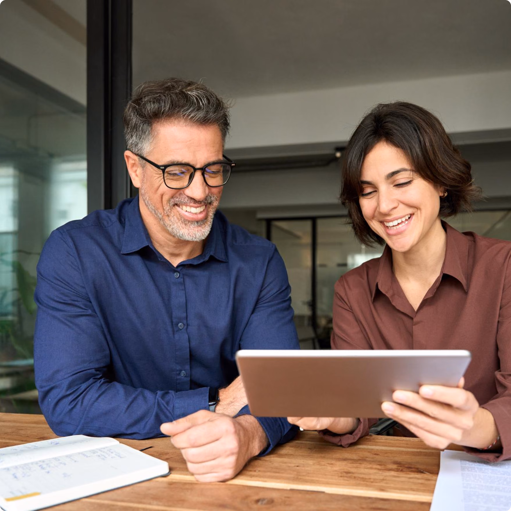 Two colleagues reviewing shipment details together on a tablet