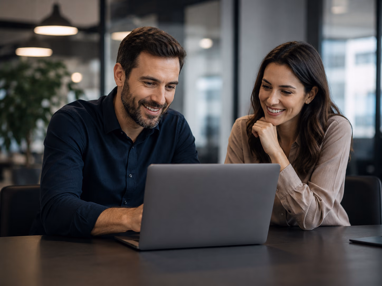 Two colleagues reviewing online orders together on a laptop
