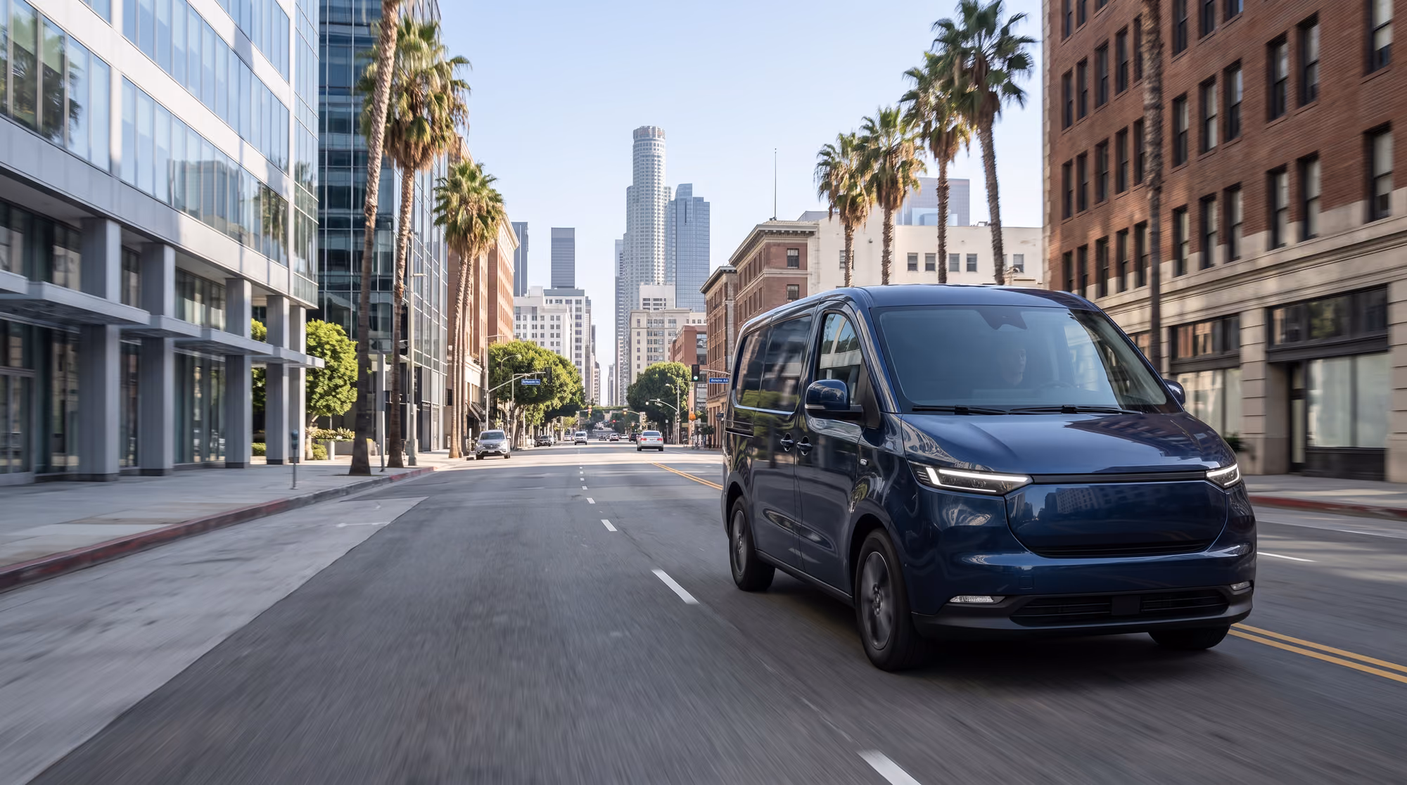 A dark delivery van driving down a sunlit city street