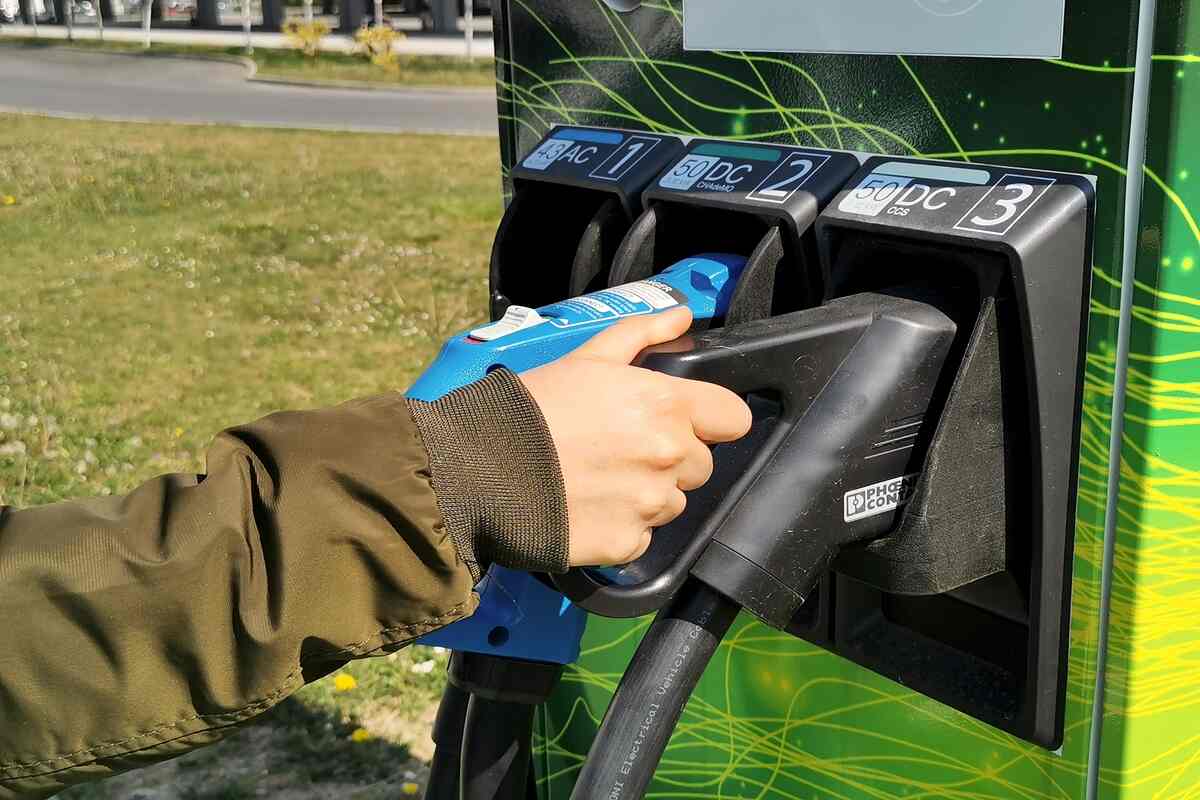 hand holding electric vehicle charger