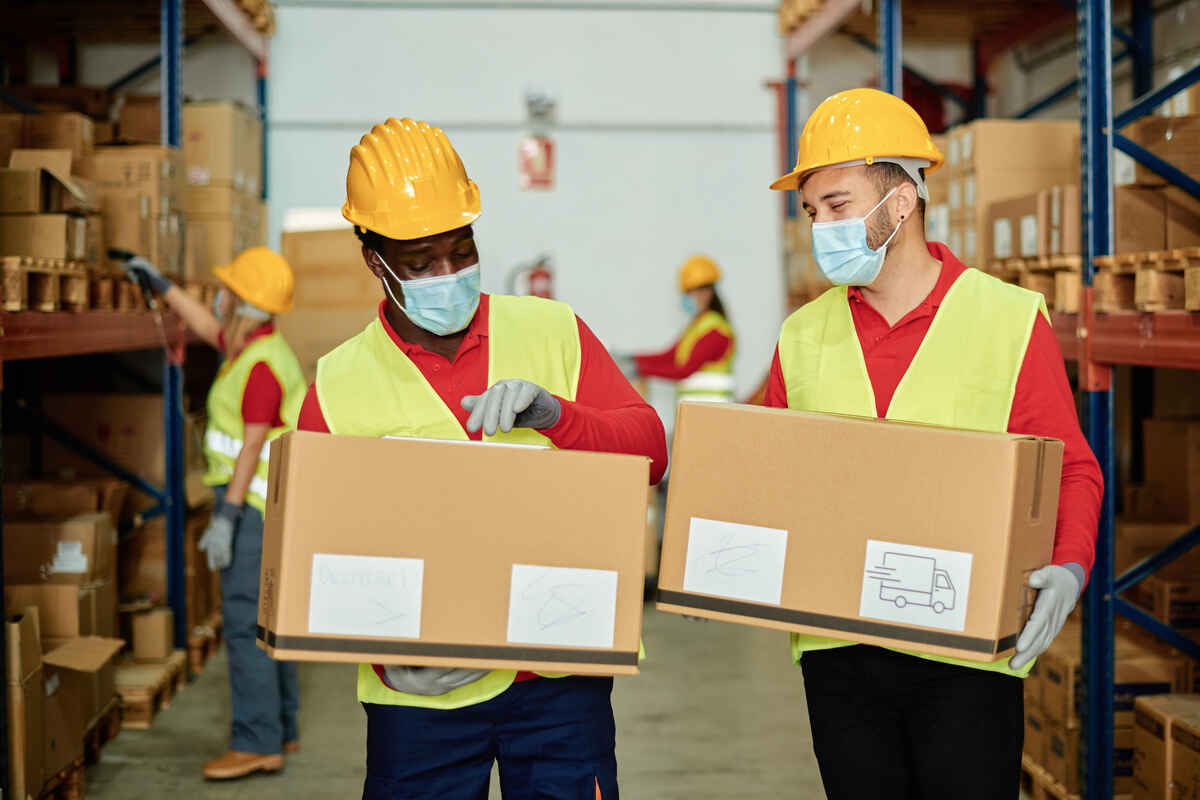 multiracial warehouse workers carring box